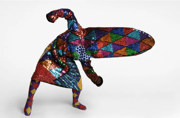 Persona con traje colorido tipo arlequín con formas geométricas