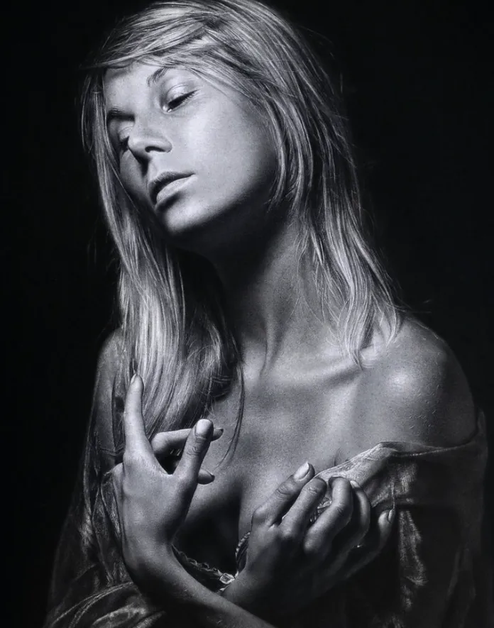 “Retrato hiperrealista de una mujer con mirada introspectiva, dibujado por Emanuele Dascanio con técnica de grafito y claroscuro sobre fondo oscuro.”