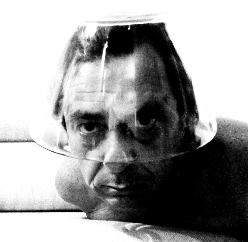 Retrato en blanco y negro de un rostro distorsionado por un cuenco transparente, en posición horizontal