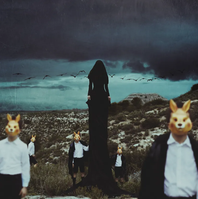 Figura central encapuchada rodeada por cinco personas con máscaras de animales en un paisaje oscuro y montañoso. Imagen cargada de misterio y ritualidad, que refleja el lenguaje visual introspectivo y simbólico de Frank Diamond.