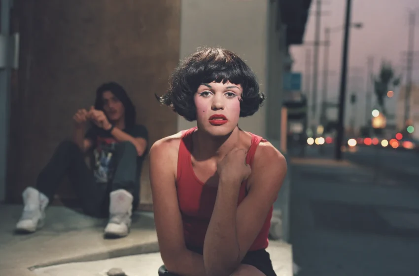 Fotografía de Philip-Lorca diCorcia: joven con camiseta roja sentado en una acera al atardecer