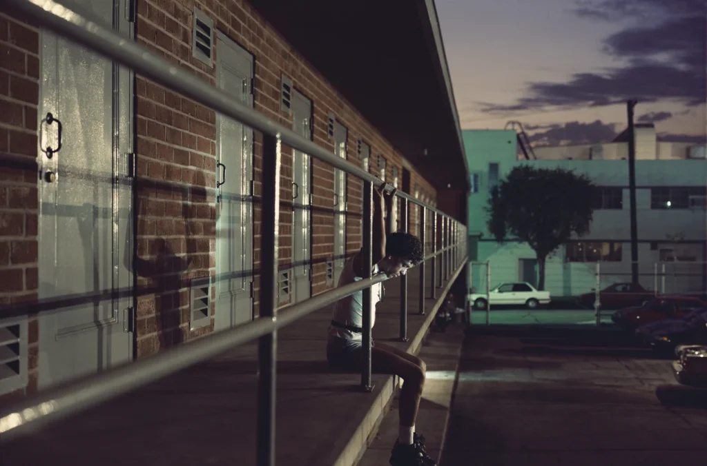 Fotografía de Philip-Lorca diCorcia: persona sola en pasarela de edificio al atardecer