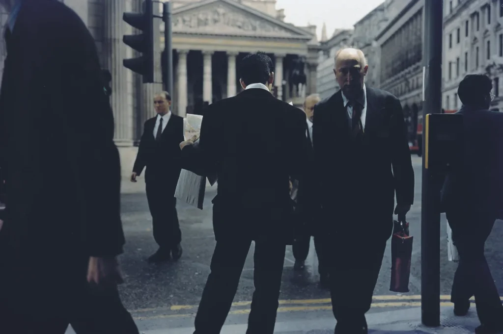 Fotografía de Philip-Lorca diCorcia: hombre con periódicos frente a edificio neoclásico en distrito financiero