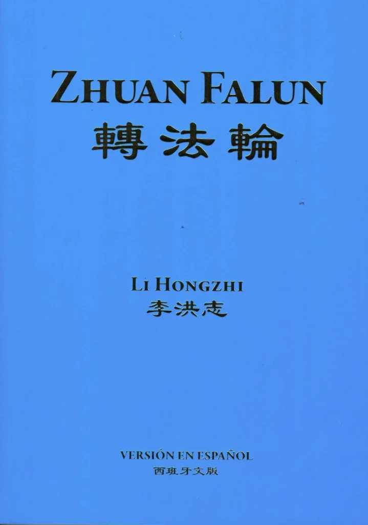 Libro Zhuan Falun en su edición en español, con portada azul y texto en inglés, chino y español.