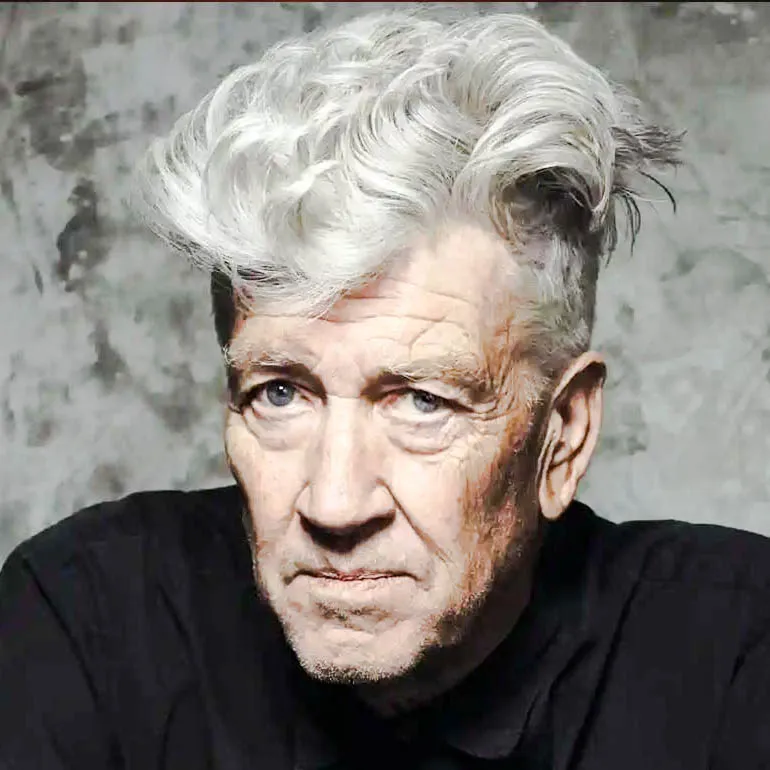 Retrato de David Lynch con peinado voluminoso y expresión intensa, sobre fondo gris texturizado.