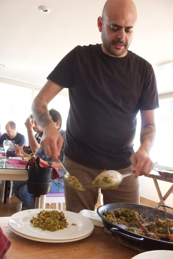 Pedro del Mar y Paz sirviendo una paella de marisco recién hecha