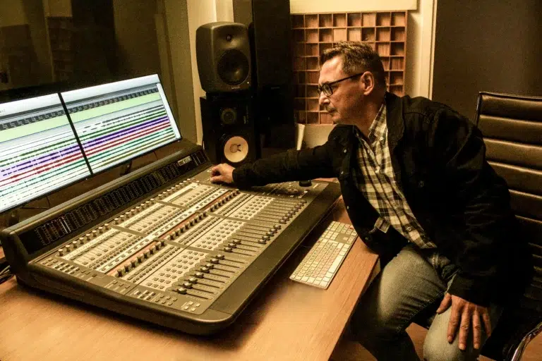 Productor musical ajustando mesa de mezclas en un estudio de grabación profesional