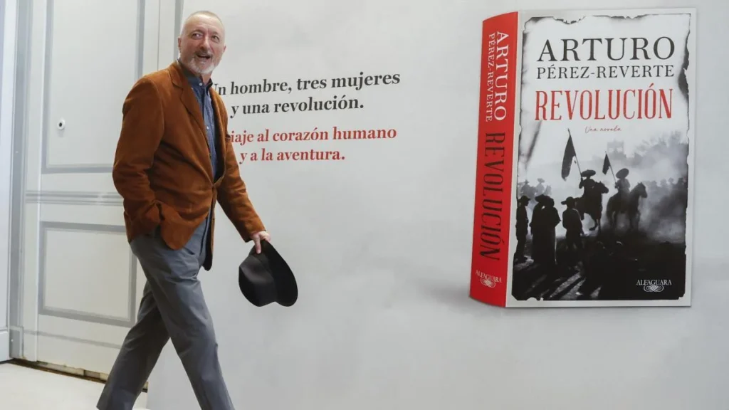 Persona caminando frente a un gran anuncio mural del libro Revolución de Arturo Pérez?Reverte.