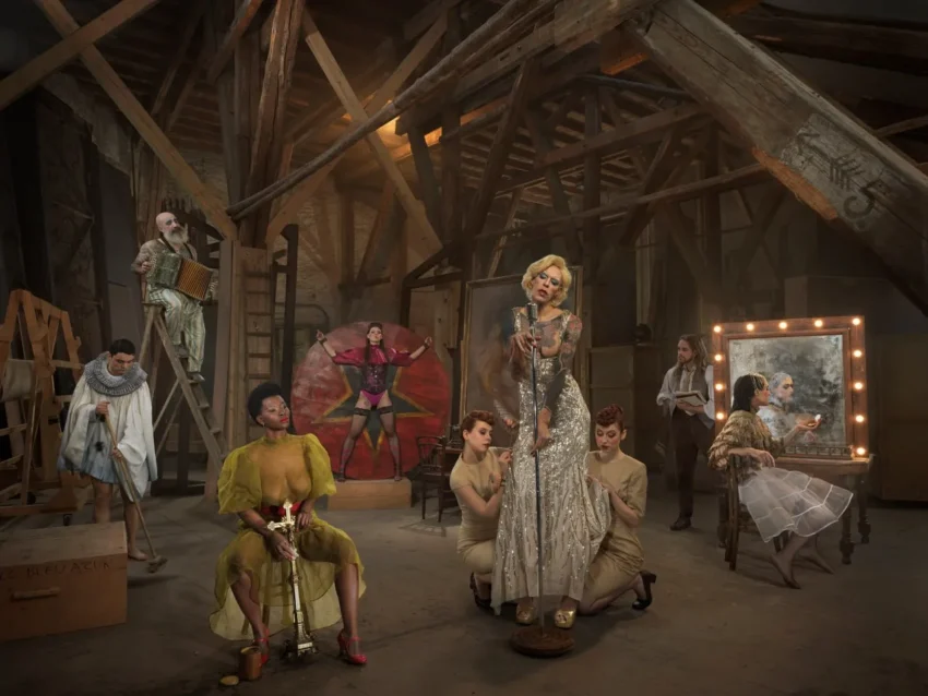 Escena teatral en ático con artistas en vestuario vintage y accesorios escénicos