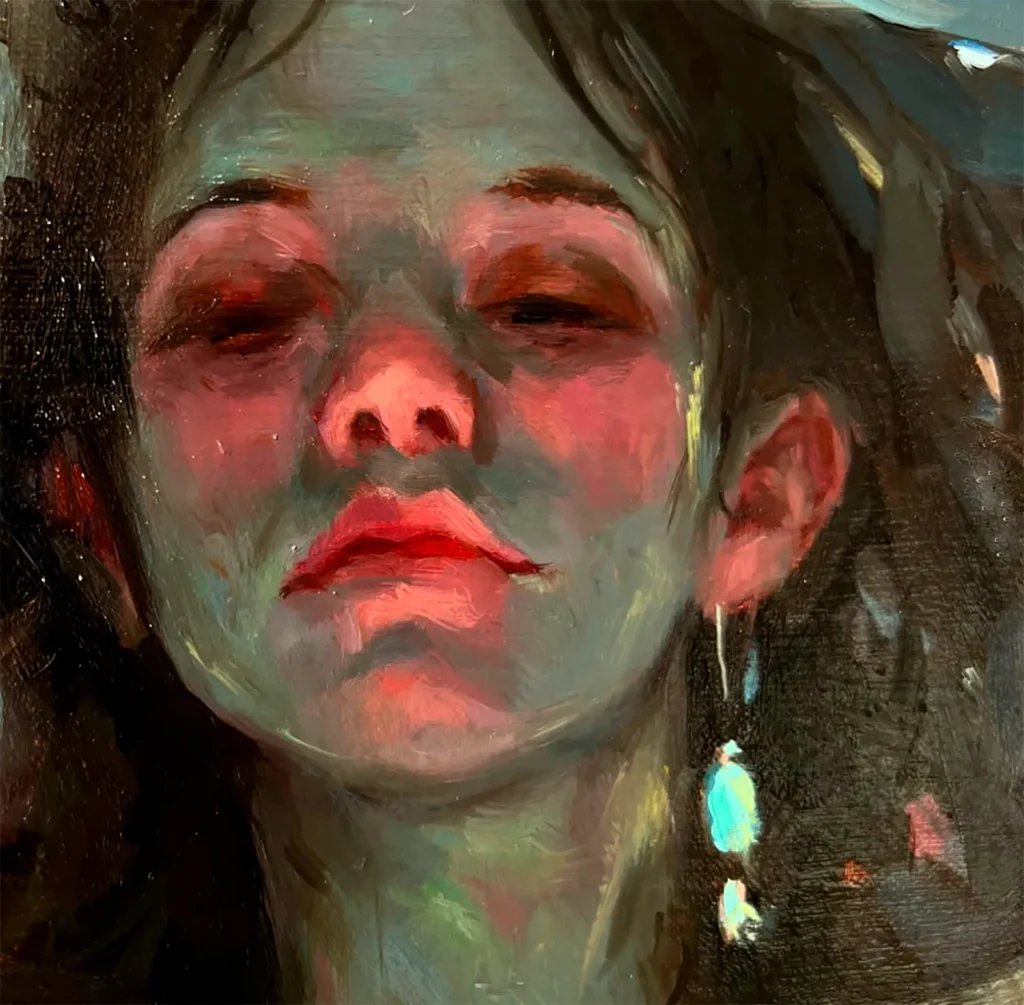 Retrato de @nailcunning al rostro de una chica joven, cara con iluminación roja, mirando abajo