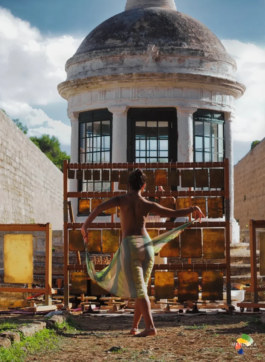 Performer descalzo frente a estructura abovedada en el Lazareto de Maó durante Quarantine 2025.