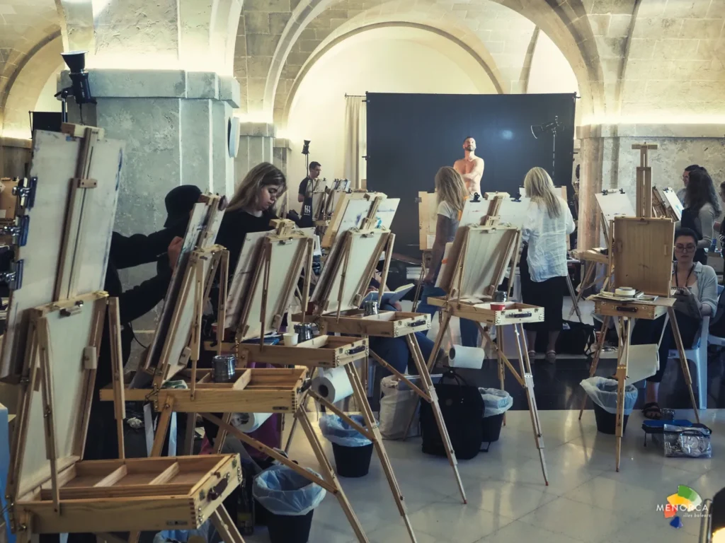 Participantes dibujando a un modelo masculino durante una sesión de dibujo en vivo en el Lazareto de Maó, parte de la edición Strange Heaven de Quarantine 2025.