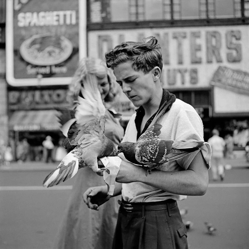 Fotografía de Vivian Maier: joven con dos palomas en una calle urbana
