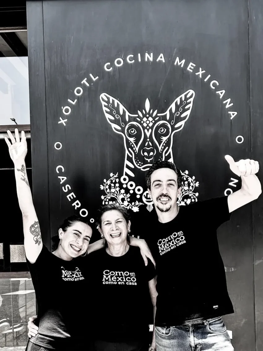 Equipo de Xólotl frente al cartel del restaurante con el lema “O casero como en casa”