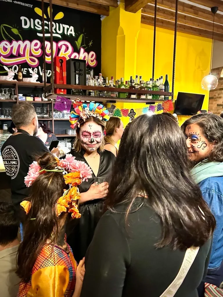 Celebración de Día de los Muertos en Xólotl con maquillaje tradicional y decoración festiva