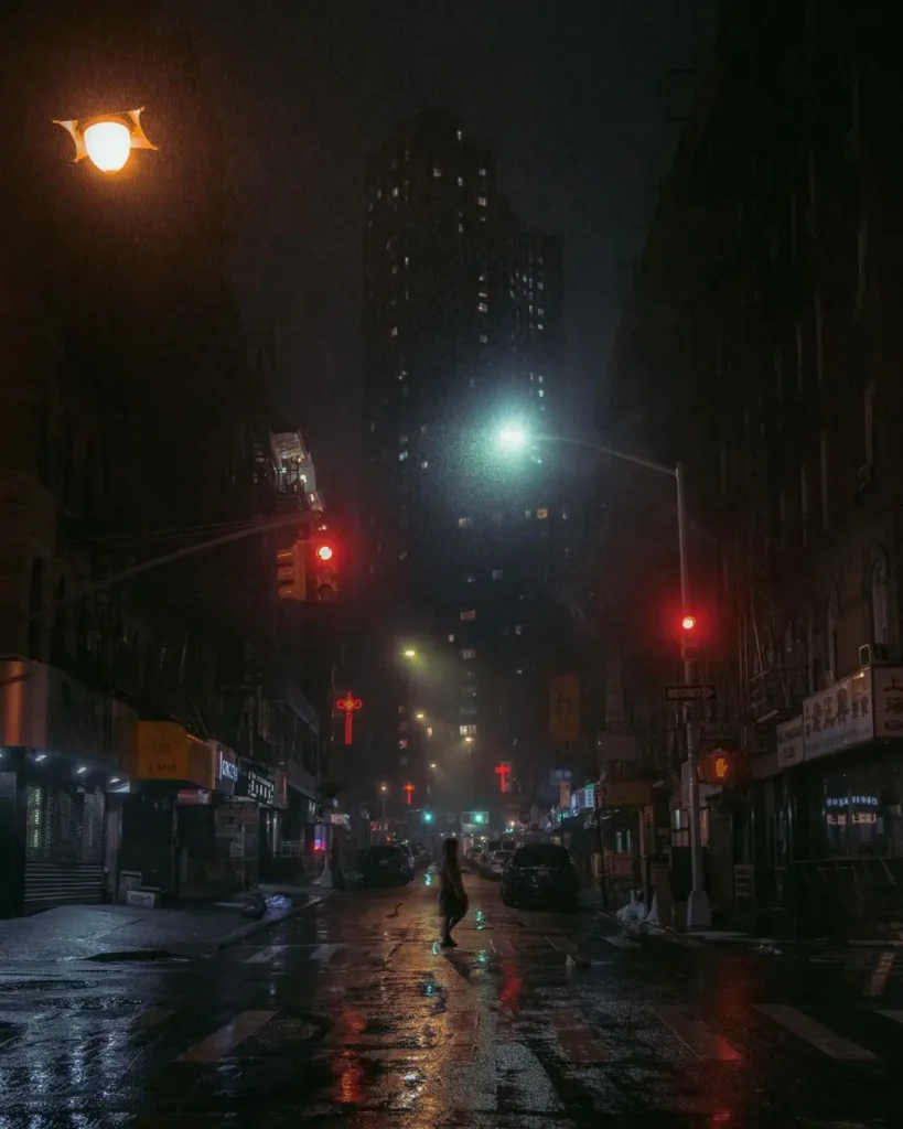 Fotografía de Nicolas Miller en Chinatown, Nueva York, con neón rojo, niebla y figura cruzando la calle.
