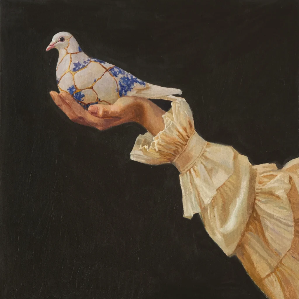 Mano con paloma de cerámica restaurada con Kintsugi y motivos florales azules
