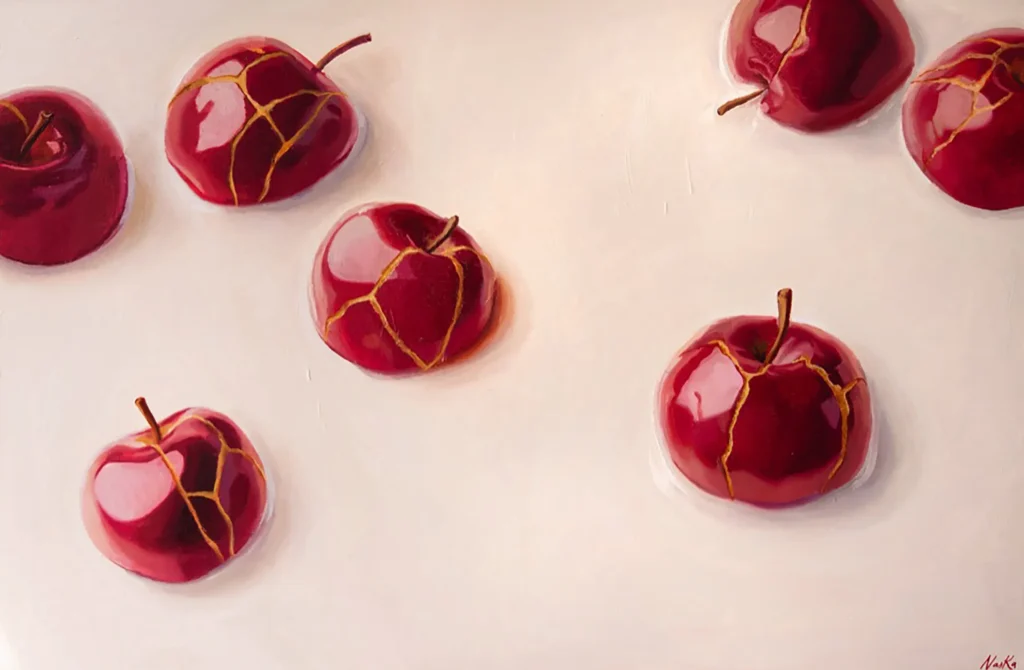 Seis manzanas rojas con grietas doradas estilo Kintsugi sobre superficie clara