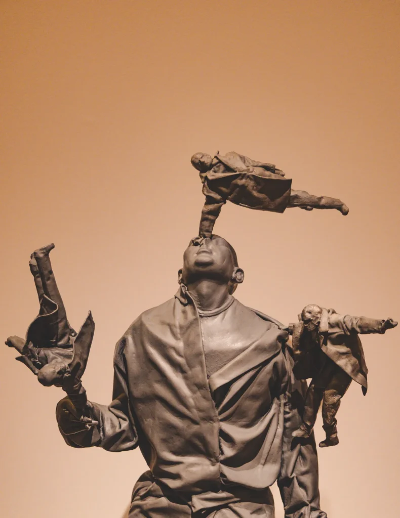 Escultura de Juan Muñoz con figura central y múltiples cuerpos emergentes en actitud expresiva y dramática.