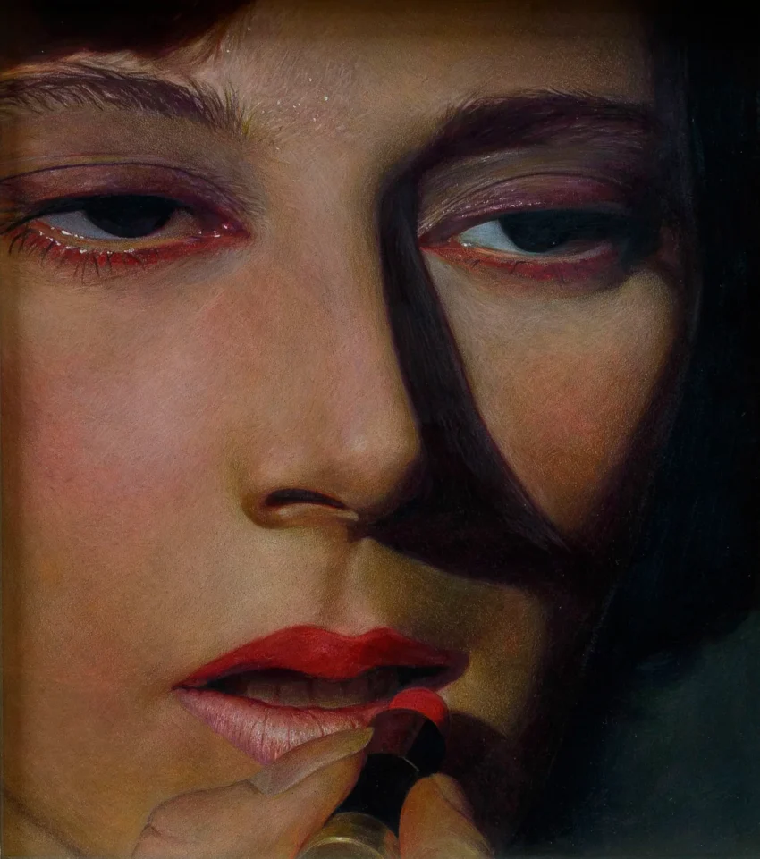 Primer plano de rostro maquillado aplicando pintalabios rojo bajo sombras dramáticas