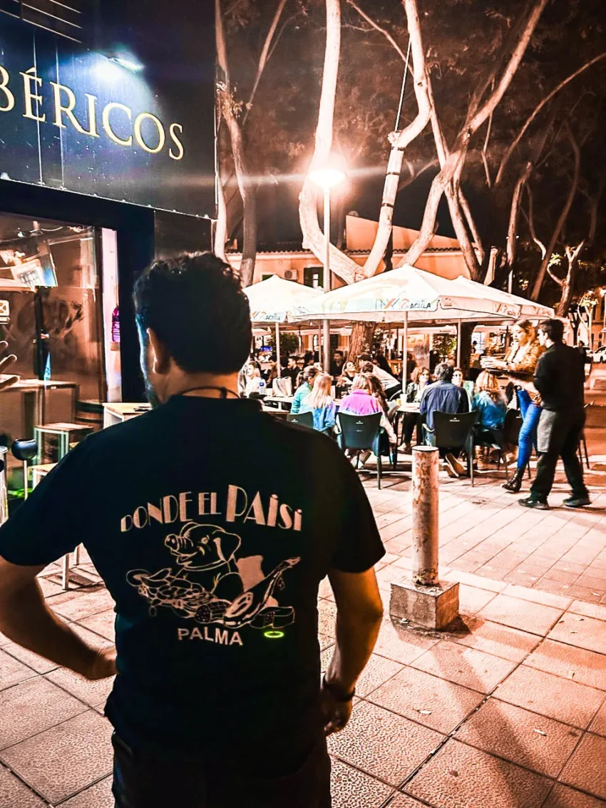 Escena nocturna frente al restaurante Donde el Paisi, con luces cálidas y figura en primer plano.