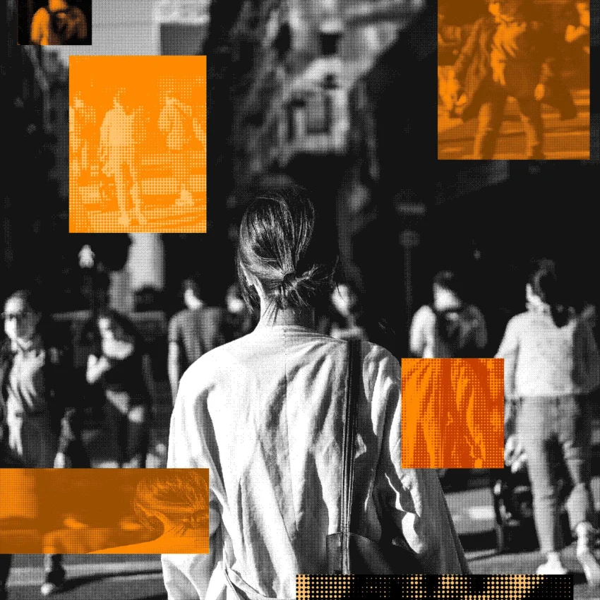 Persona caminando por una calle urbana concurrida en blanco y negro, con varios peatones alrededor y áreas resaltadas en color naranja.