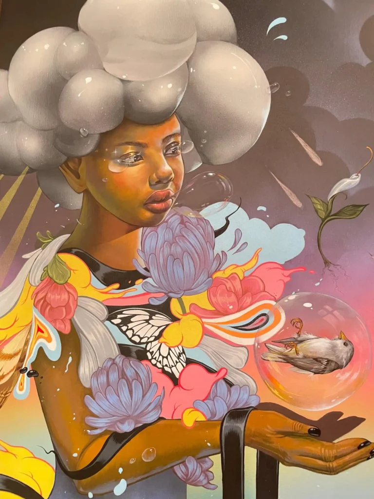 Figura con cabello en forma de nubes sosteniendo una esfera con un pájaro, rodeada de flores y elementos surrealistas en una obra pop de Kayla Mahaffey