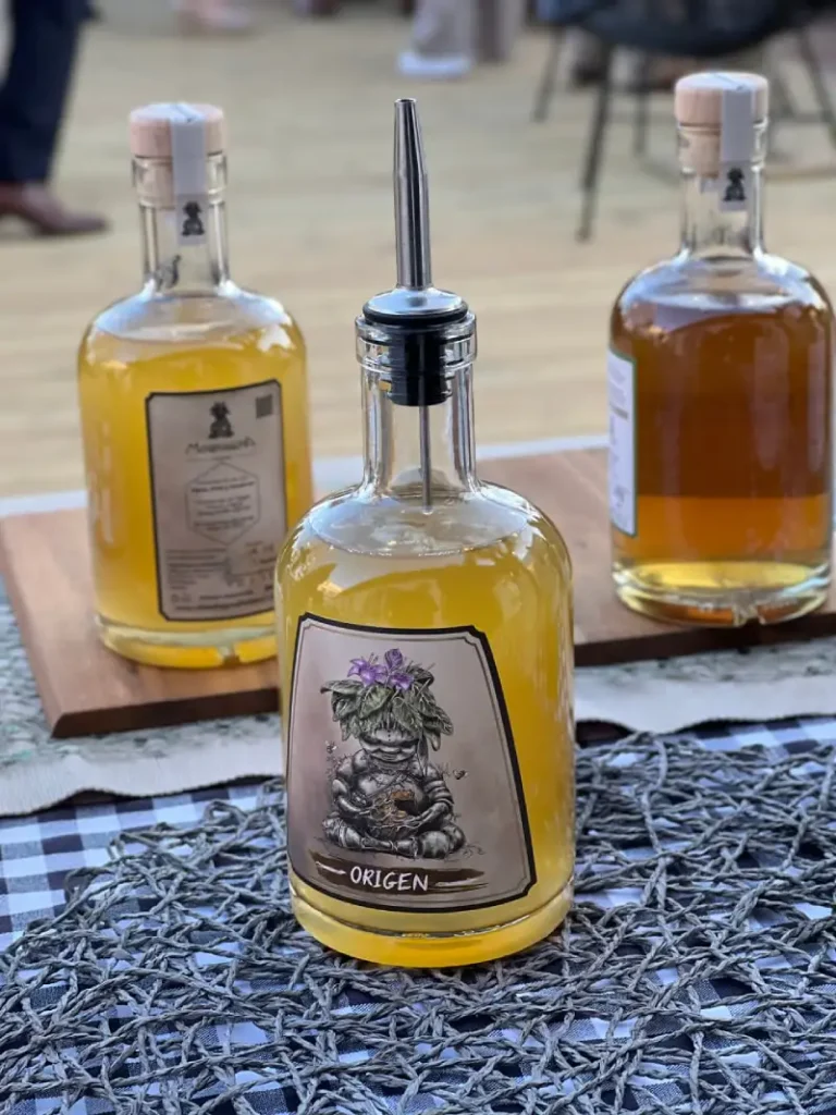 Botellas artesanales de hidromiel Mandrágora sobre una mesa de madera, con etiqueta ilustrada y tonos dorados.