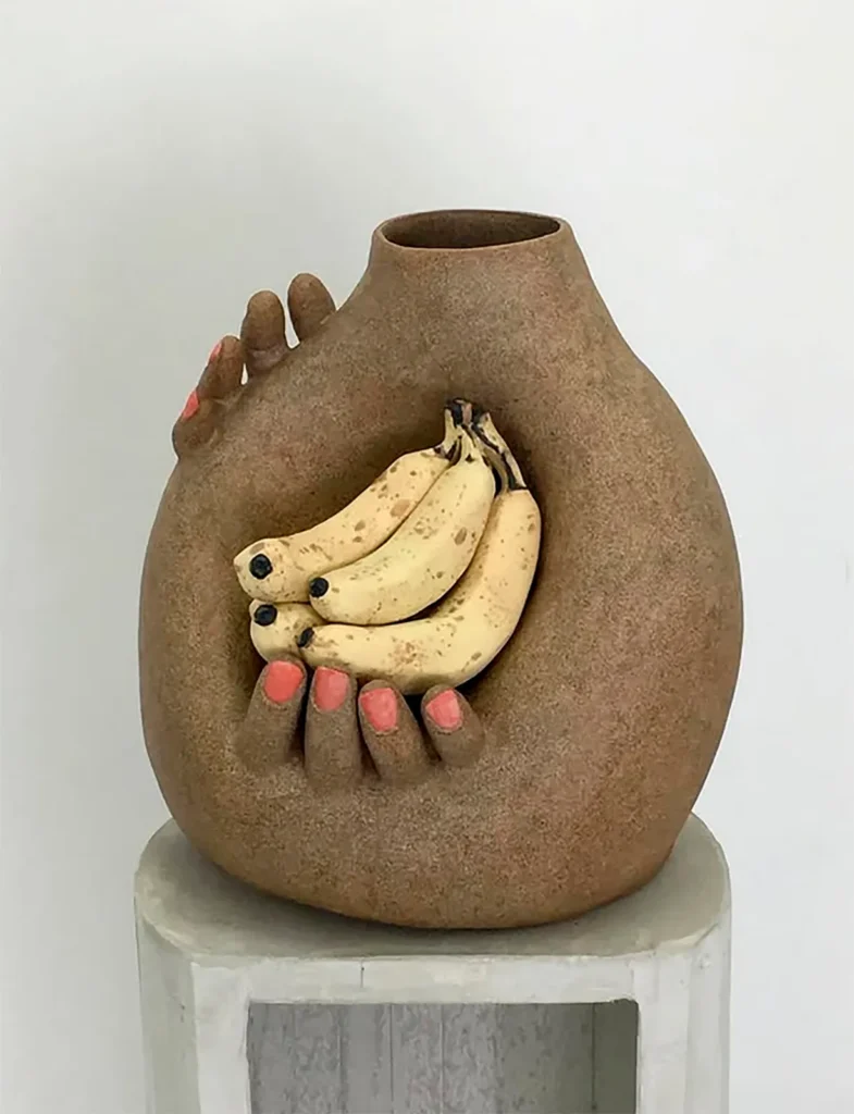 Genesis Belanger es una artista estadounidense conocida por sus esculturas de cerámica en tonos pastel que transforman objetos cotidianos en escenas sutilmente surrealistas y cargadas de subjetivismos. Sus misteriosas instalaciones realizadas con cerámicas y objetos de hormigón fundido adquieren rasgos humanos, lo que las hace atractivas y ligeramente inquietantes al mismo tiempo. Bajo todos estos suaves tonos, la obra de Belanger toma un giro más oscuro.