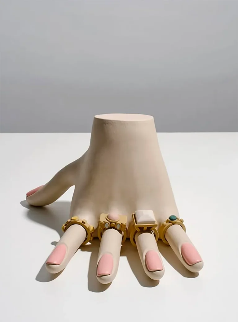 Genesis Belanger es una artista estadounidense conocida por sus esculturas de cerámica en tonos pastel que transforman objetos cotidianos en escenas sutilmente surrealistas y cargadas de subjetivismos. Sus misteriosas instalaciones realizadas con cerámicas y objetos de hormigón fundido adquieren rasgos humanos, lo que las hace atractivas y ligeramente inquietantes al mismo tiempo. Bajo todos estos suaves tonos, la obra de Belanger toma un giro más oscuro.