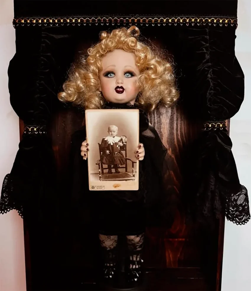 Muñeca artística de Clarobscura Art sosteniendo un retrato antiguo en una escena oscura y teatral